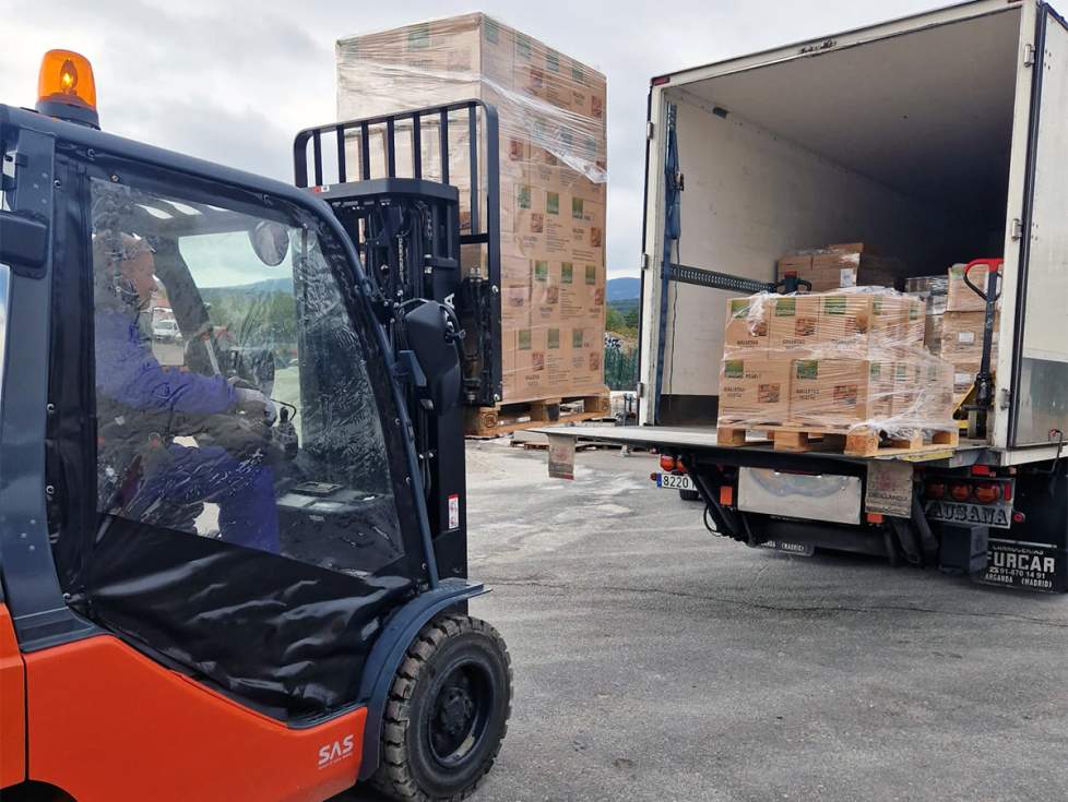 Toro mecánico introduce un palet con alimentos en un camión.