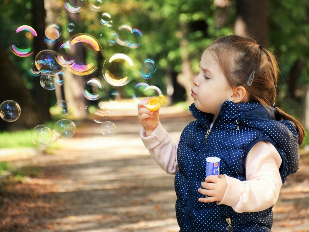 Niña soplando pompas de jabón